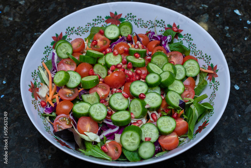 Delicious looking and healthy bowl of Salad with tomatoes, cucumber, lettuce, onion, olives and more