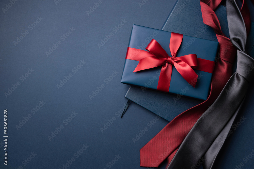 Blue gift box, notebook and neckties on dark blue background. - obrazy, fototapety, plakaty 