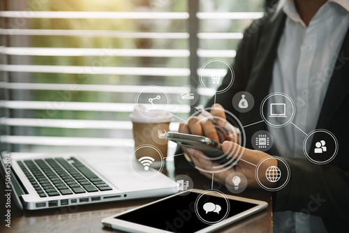 Business men hand using smart hone and tablet payments online shopping, omni channel, digital tablet docking keyboard computer at office in sun light.