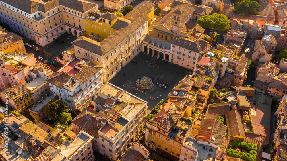 Aerial view at sunset of Piazza Santa Maria in Trastevere in Rome, Italy. In the center of the square is the famous fountain.