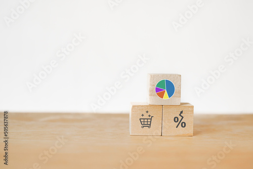 circle graph showing market share portion on wooden cube blocks with shopping cart and increasing percent symbol included copy space