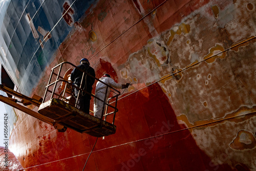 Fotobehang Workers working in a shipyard and painting in naval industry