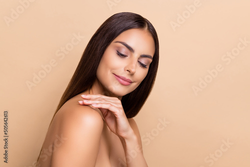 Profile side view portrait of attractive cheery dreamy girl touching flawless soft skin isolated over beige pastel color background