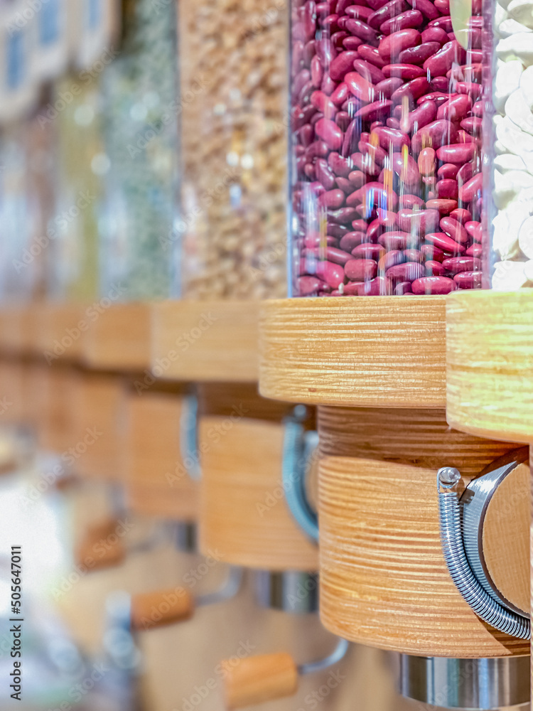 Obraz premium Eco-friendly zero waste shop. Dispensers for cereals, nuts and grains in sustainable plastic free grocery store. Bio organic food. Shopping at small local businesses. New trend alternative buying.