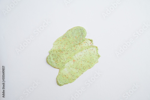 A sample of a natural green scrub on a white background. Peeling cream with microcapsules. Smear of apple or coffee scrub