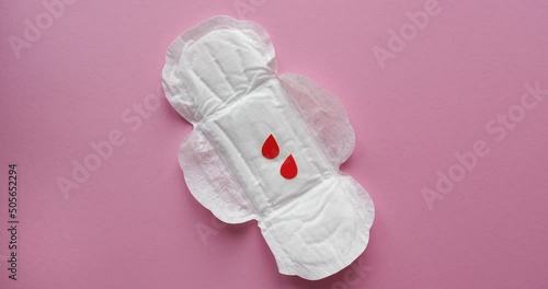 Women's sanitary napkins and drops of blood cut out of paper. Menstrual cycle. Looped 4K stop motion animation photo
