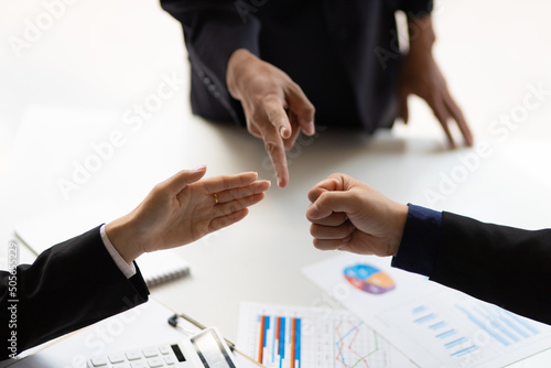Close-up of businessman playing rock-paper-scissors on a meeting table in the office. The concept of conflict in the organization. photo