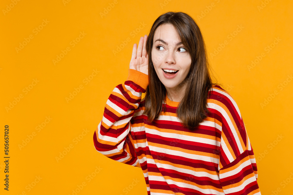 Φωτογραφία Young happy curious nosy caucasian woman 20s wearing red striped sweatshirt try to hear you overhear listening intently isolated on plain yellow background studio portrait