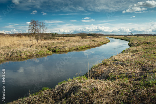 A bend in the calm river and clouds on the sky