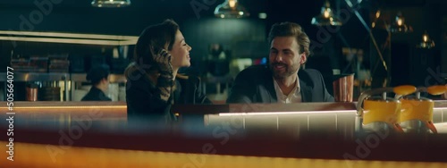 Beautiful Caucasian couple having a date in a stylish restaurant, talking and laughing. Shot with 2x anamorphic lens photo