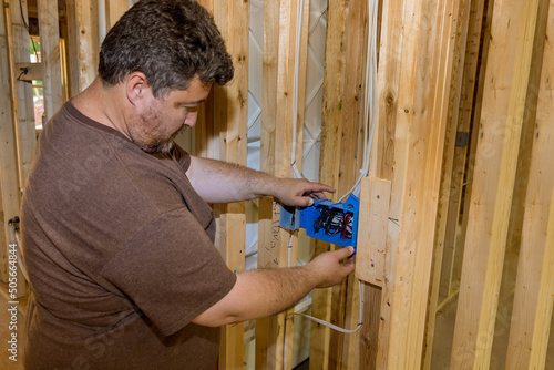 Φωτογραφία Electrician routing wires in electric plug connector, electric sockets on the wa