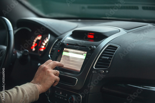 a man turns on the on-board computer display in the car while traveling