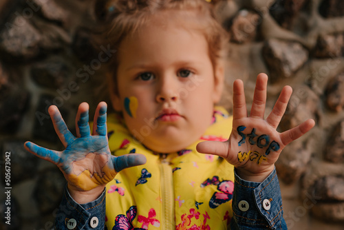 Ukrainian girl against war in Ukraine with Ukrainian map and Stop War drawing on her palms
