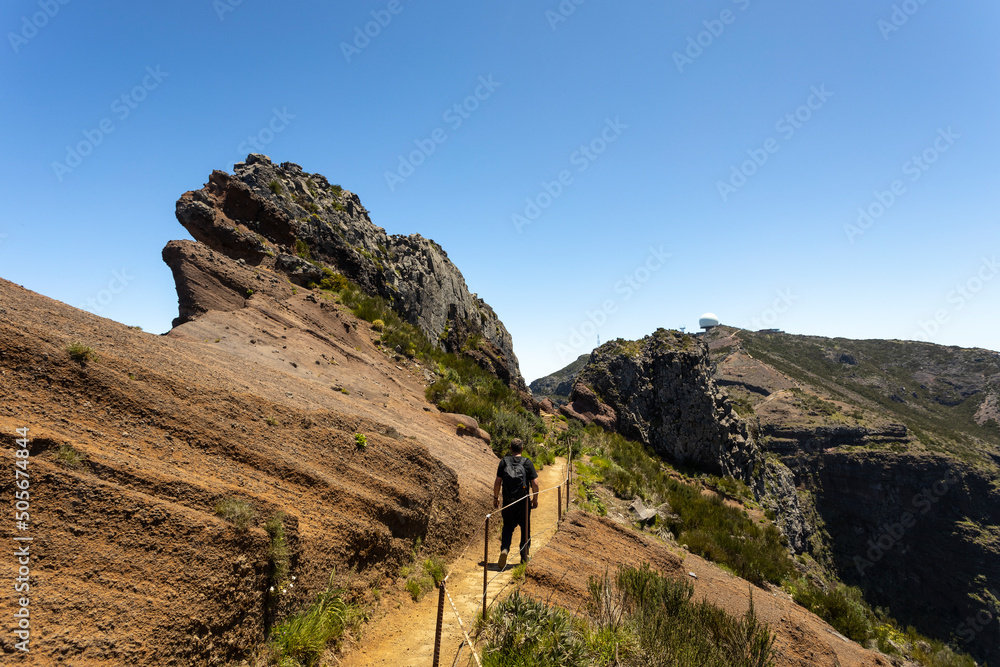 The man is hiking to Pico do Arieiro. Beautiful hiking trail in Madeira Island, Portugal.