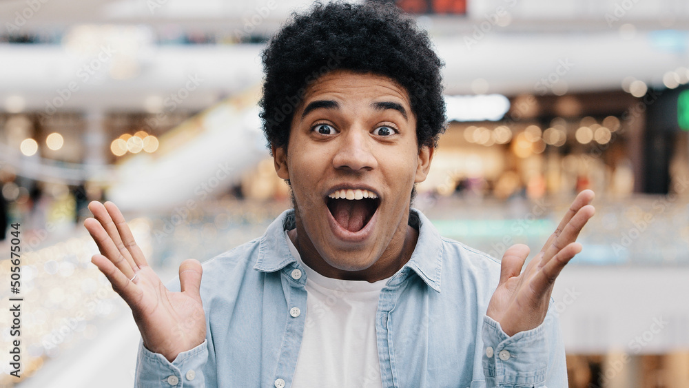 Male portrait emotions enthusiastic surprised shocked amazed man african american guy teenager looking at camera opens mouth and eyes in surprise delight winning victory luck success discount offer - obrazy, fototapety, plakaty 