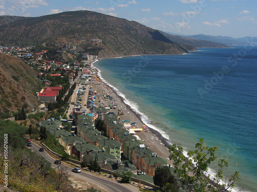 Panoramic view of the seaside town against the backdrop of mountains and the sea.