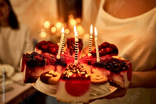 sliced ​​cherry birthday cake with candles close-up photo