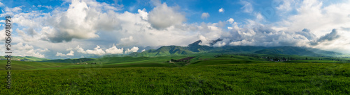 Panorama of a green mountain valley on a sunny spring day.