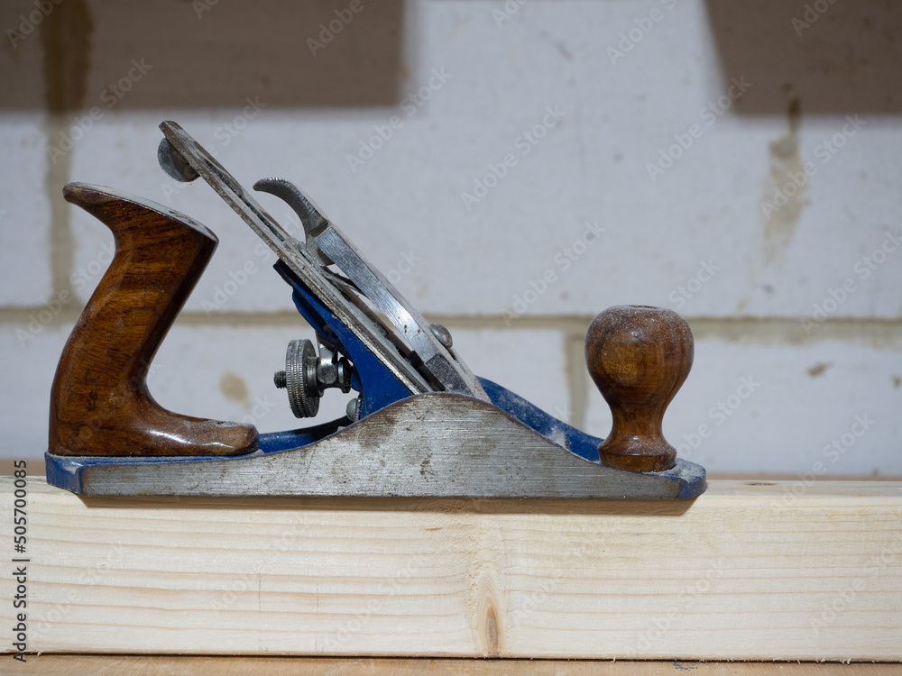 Antique woodworking hand plane on a wooden board Antique woodworking hand plane on a wooden board