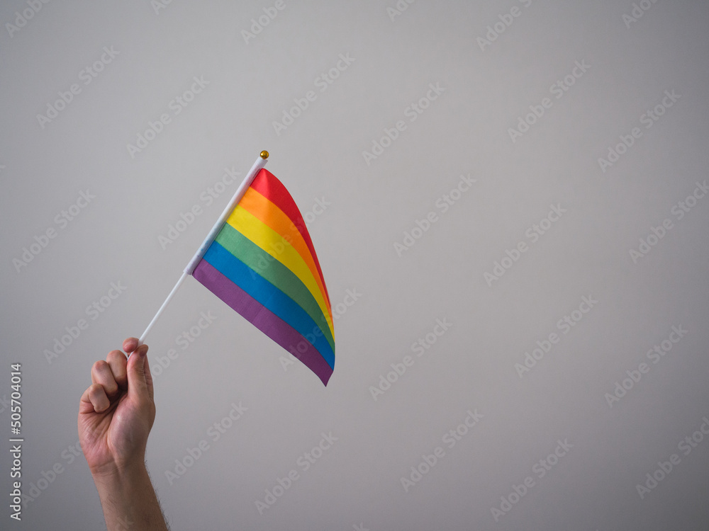 Unrecognizable person's hand with LGBT flag and copy space