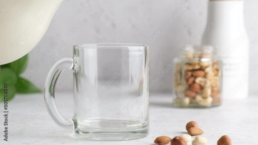 Pouring non dairy nut milk in glass. Healthy vegan milk substitute Pouring non dairy nut milk in glass. Healthy vegan milk substitute