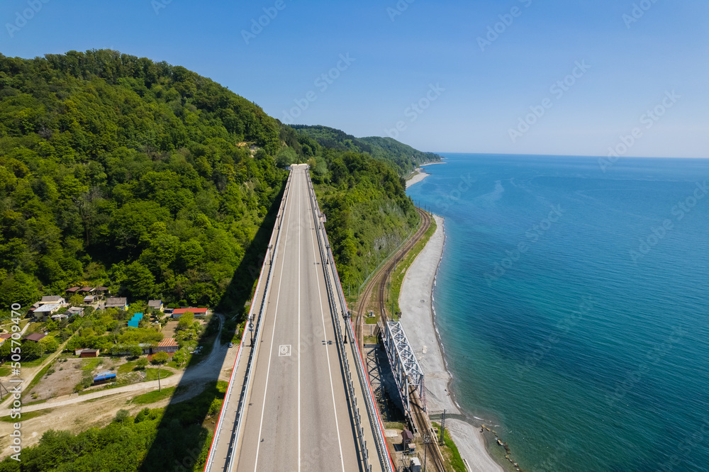 The Zubova Schel Viaduct is a road bridge, Dzhubga - Adler federal road. Aerial view of car driving along the winding mountain road in Sochi, Russia.