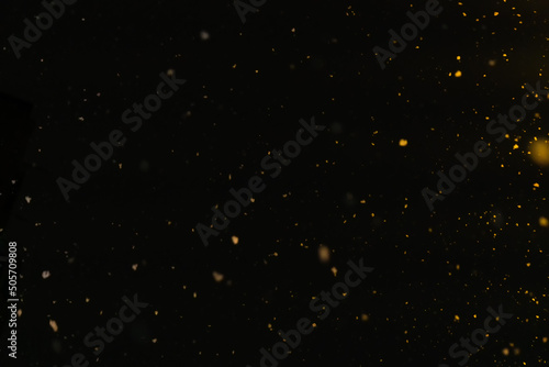 Texture of falling snow at night in the yellow light of lanterns