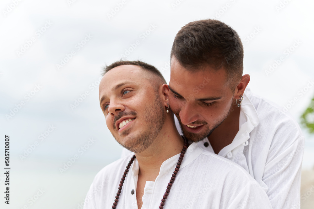 Close up photo of a gay couple in love embracing on a beach Close up photo of a gay couple in love embracing on a beach