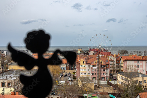 Angel on the background of a panoramic view of the city center  the sea and the Ferris wheel in Zelenogradsk  Kaliningrad region  Russia  near the Baltic sea.