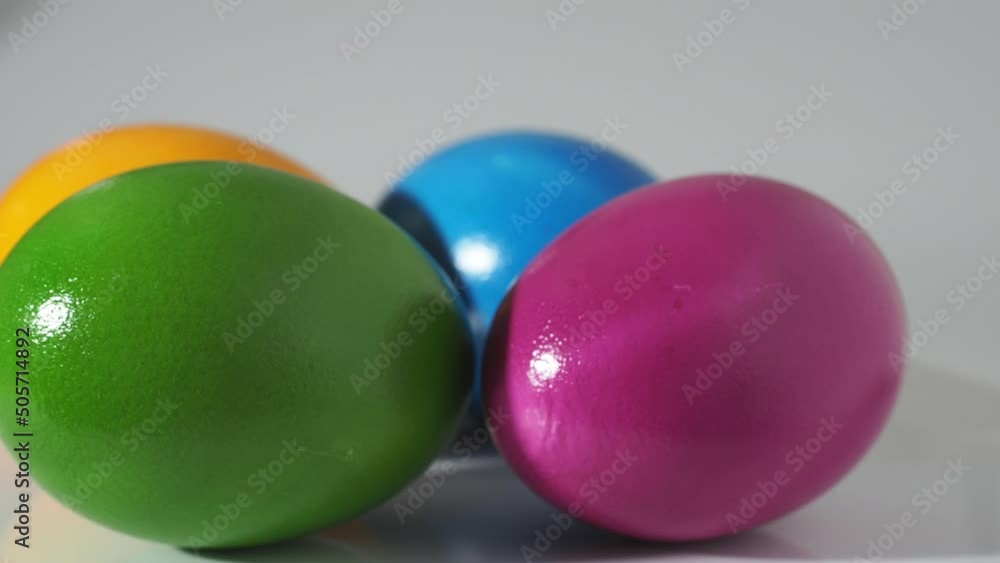 Colored eggs rotate on a white background. painted chicken eggs close-up. Colored eggs rotate on a white background. painted chicken eggs close-up.