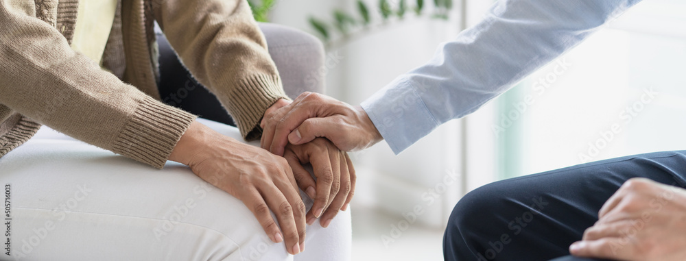mental health treatment concept. Stressed asian patient talking with personal psychologist in therapist session have a and doctor touching her hand feel empathy. - obrazy, fototapety, plakaty 