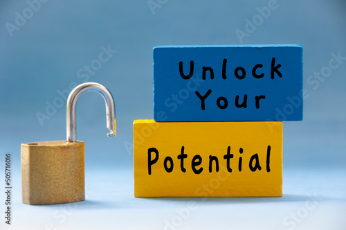 Unlock your potential text on wooden blocks with pad lock on light blue background. photo