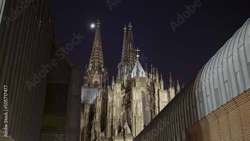 Imposing Cologne Cathedral Timelapse. Backside of the cathedral. Moon touches visually the top of the cathedral. Smooth slide with Museum Ludwig in the foreground. Scaleout 100 photo