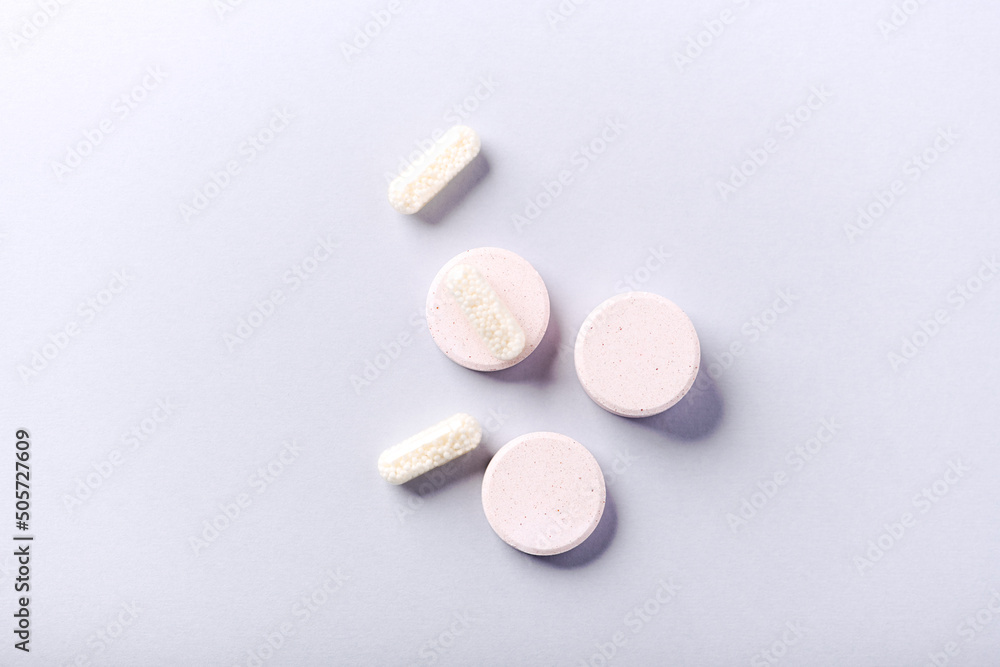 Collagen effervescent Tablets and Vitamin C tablets and capsules. Supplements to support collagen production. Bright paper background. Soft focus. Top view. Close up. Copy space. Collagen effervescent Tablets and Vitamin C tablets and capsules. Supplements to support collagen production. Bright paper background. Soft focus. Top view. Close up. Copy space.
