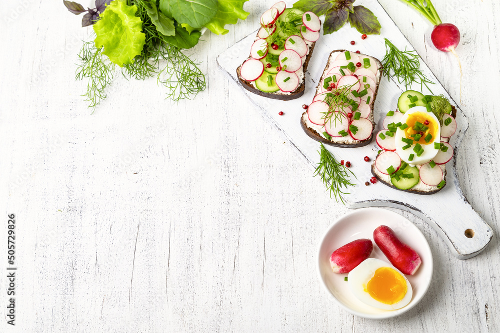 Φωτογραφία Healthy sandwiches with radish, cucumber, egg, curd cheese, sprinkled with green onions and pink pepper