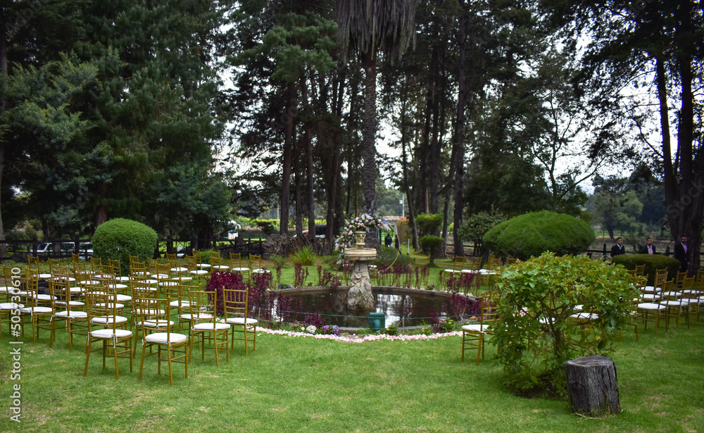 Country wedding, around a fountain, decorated with golden chairs and cushions, also a golden arch with a decoration of natural flowers, decorated with rose petals around the fountain. Country wedding, around a fountain, decorated with golden chairs and cushions, also a golden arch with a decoration of natural flowers, decorated with rose petals around the fountain.