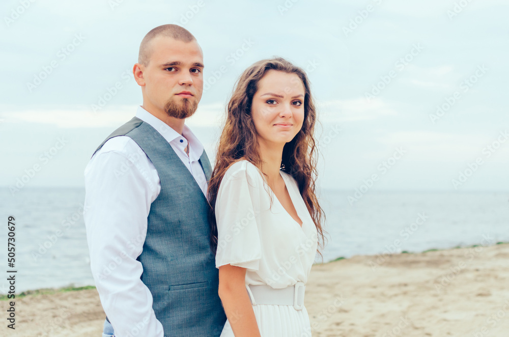 Husband and wife are photographed by the sea