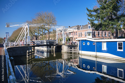 Canal quay covered in bright sunshine and floating home boats on the Leidse rijn canal in Lombok neighbourhood in Utrecht photo