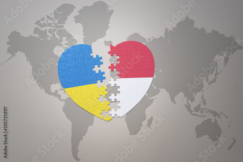 puzzle heart with the national flag of ukraine and indonesia on a world map background. Concept.