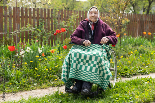 Φωτογραφία Old woman sitting in a wheelchair looking sad and worried