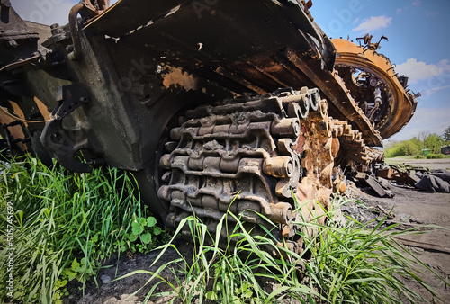 Kyiv region, Ukraine - May 15, 2022: War in Ukraine. Highway Kyiv - Zhytomyr. People take selfies against destroyed russian tank after russian atack in Febrary. photo