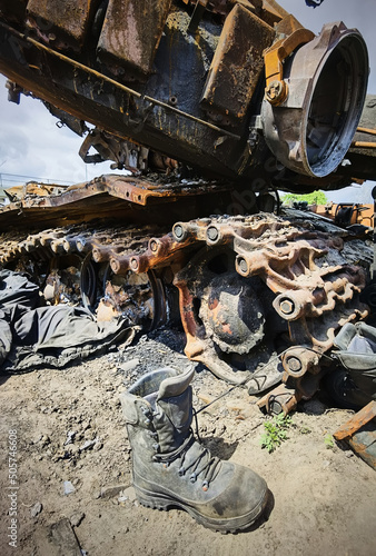 Kyiv region, Ukraine - May 15, 2022: War in Ukraine. Highway Kyiv - Zhytomyr. People take selfies against destroyed russian tank after russian atack in Febrary. photo