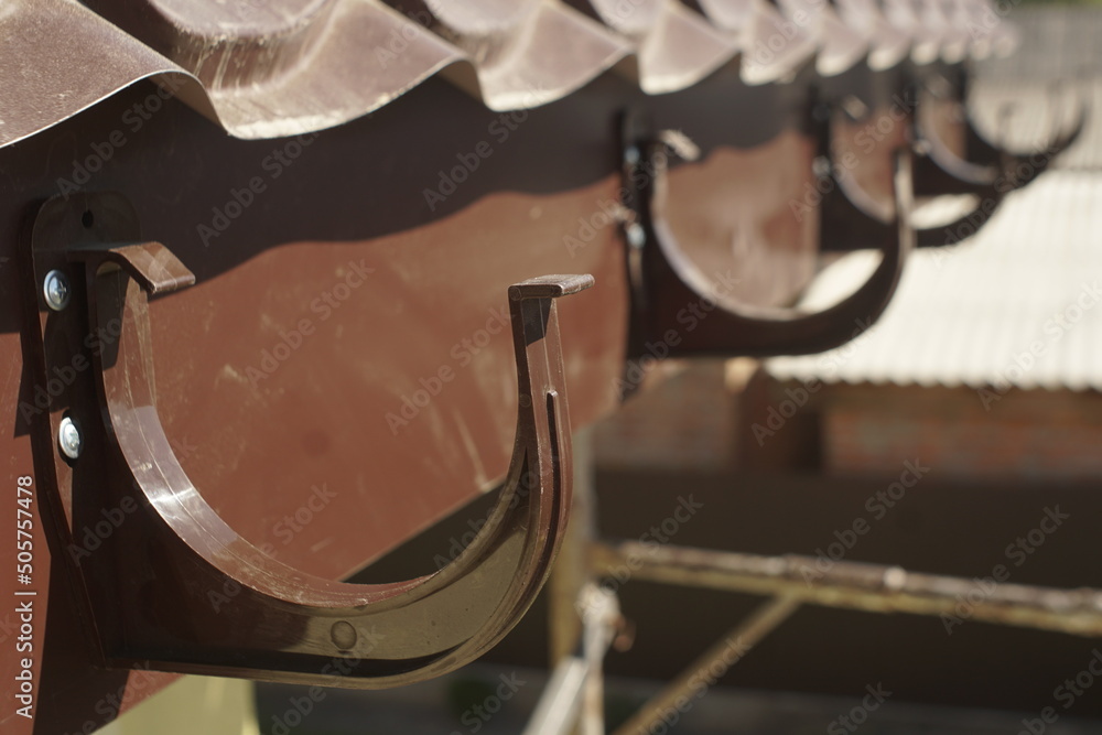 nstallation of plastic brackets for gutters. Installation of drainage system on the roof nstallation of plastic brackets for gutters. Installation of drainage system on the roof