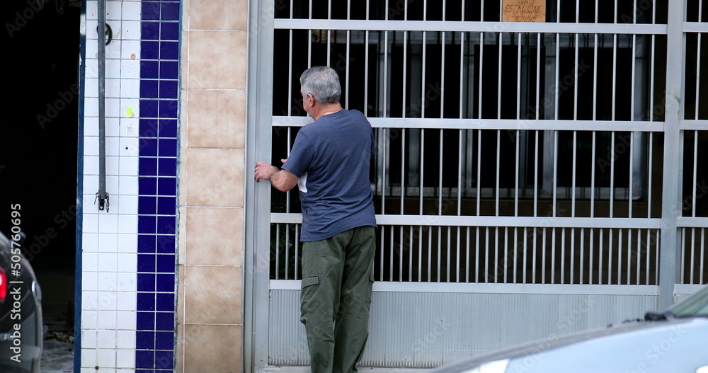 Older man opening iron gate entrance. Casual person entering home Older man opening iron gate entrance. Casual person entering home