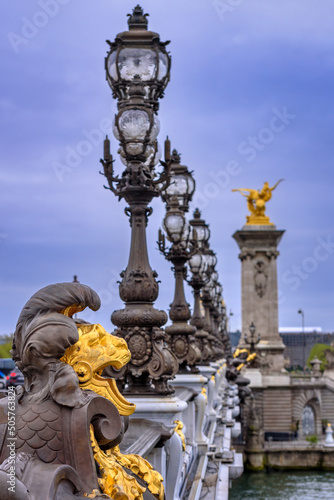 The ornate statues and candelabras of the famous Pont Alevmxandre III above the Seine River in the downtown of Paris, France  © petertakacs