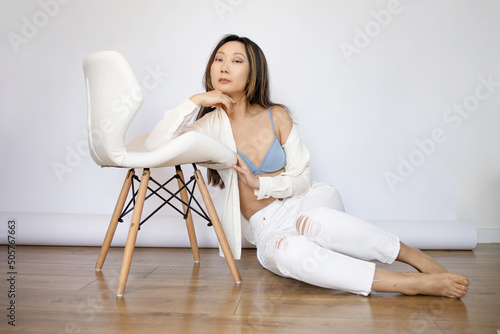 Portrait of asian woman in bra lingerie underwear. Portrait of beautiful Asian woman wearing white shirt and jeans posing in studio.