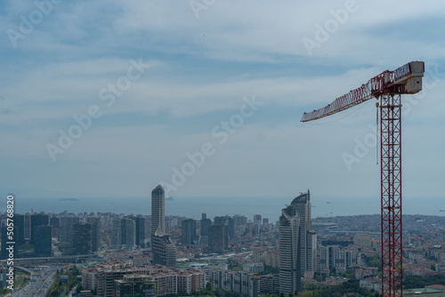 A high-rise construction crane against the background of the city view of Istanbul with the interchange and skyscrapers, Turkish photo