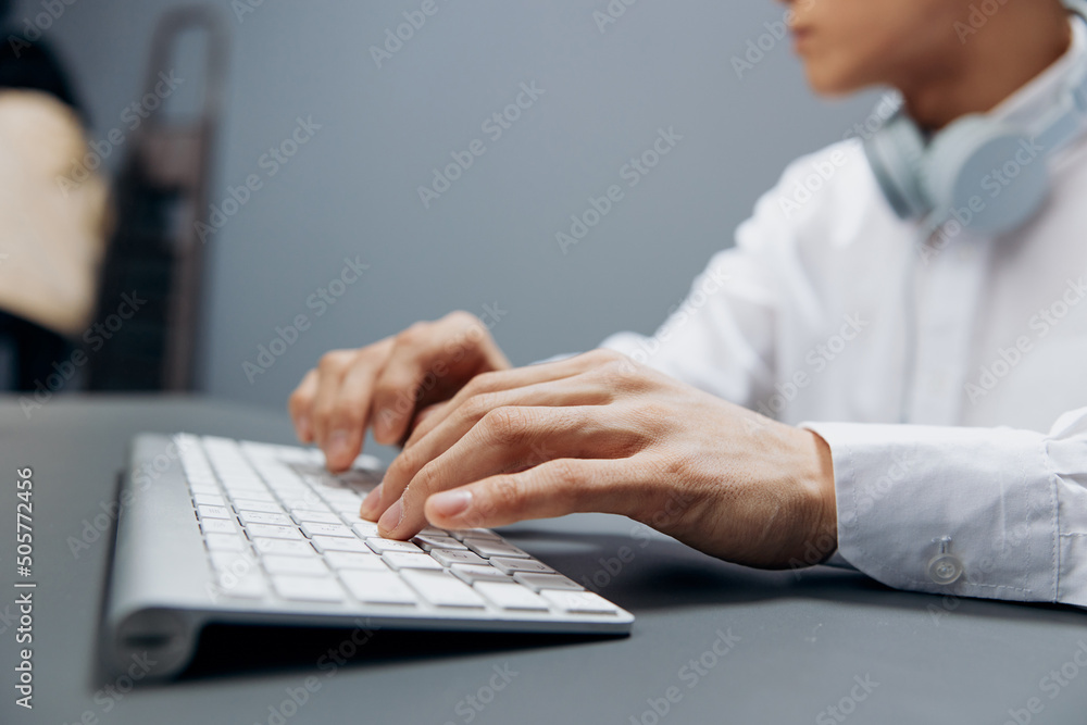 worker in headphones hands on keyboard office work close-up isolated background worker in headphones hands on keyboard office work close-up isolated background
