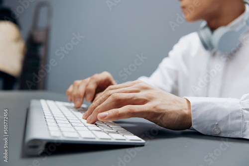 worker in headphones hands on keyboard office work close-up isolated background