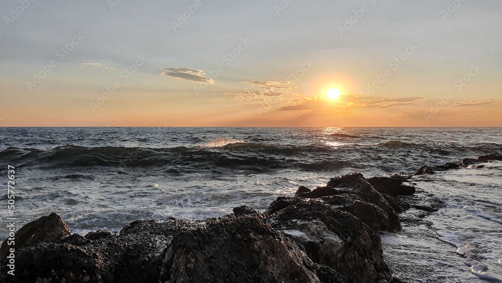 Colorful sunset with large sun under the sea waves. Colorful sunset with large sun under the sea waves.
